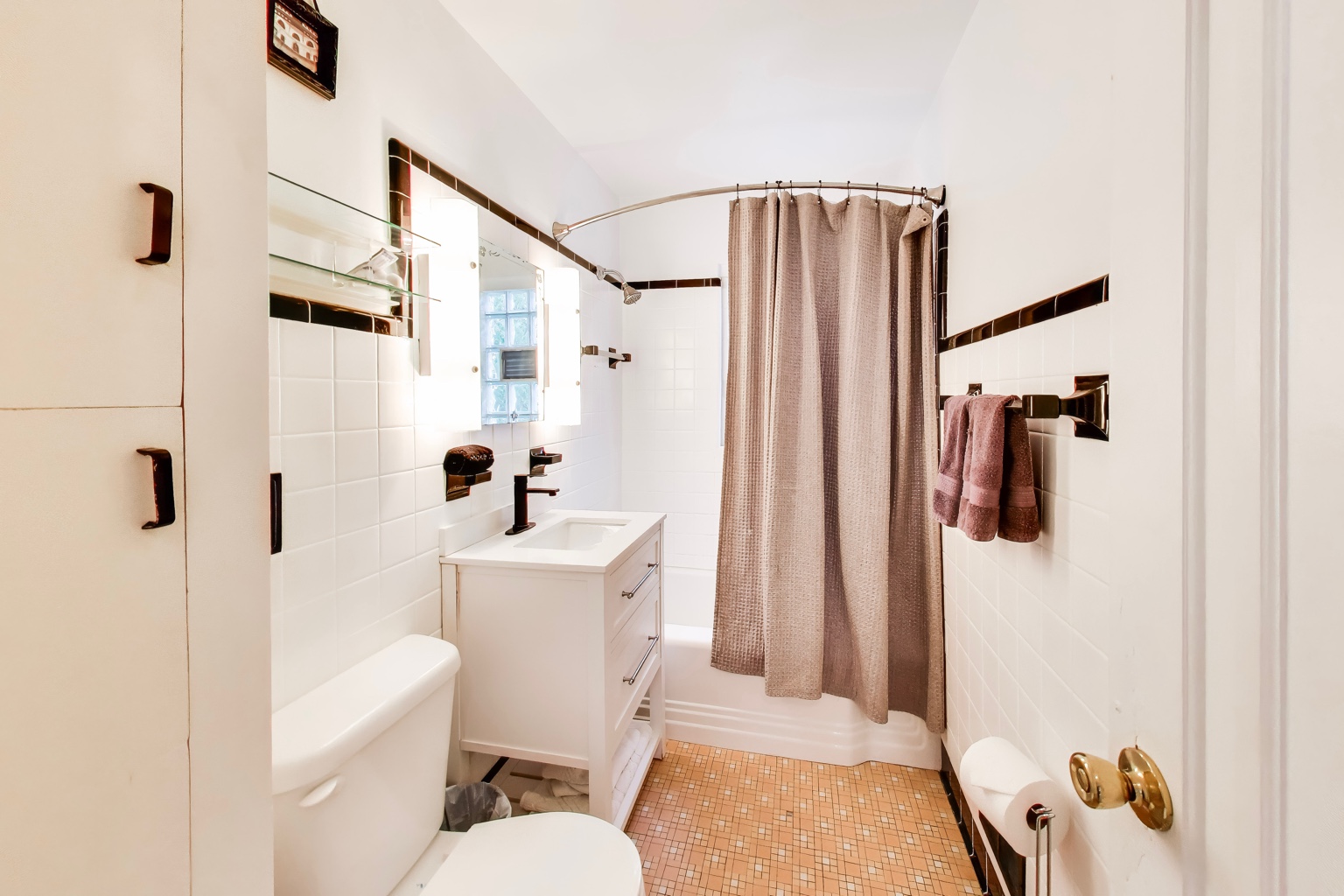 Bathroom at Emmet’s Place with a shower, vanity, and white tile