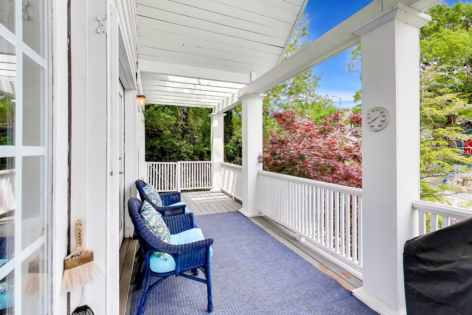Covered porch with outdoor chairs and leafy neighborhood views